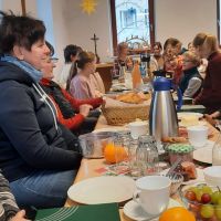 eine lange reichlich gedeckte Fr&uuml;hst&uuml;cks-Tafel mit viele Menschen - 1. Fr&uuml;hst&uuml;cks- Gottesdienst am 25.01.2026 in Triebel
