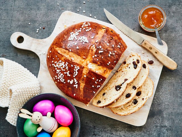 Osterbrot angeschnitten neben Ostereiern