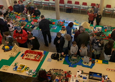 Lego-Tage: VIele Kinder und Mitarbeiter scharen sich um mehrere Tische mit vielen Legobauten