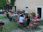 10 Jahre Chor Geilsdorf – wir feiern! (Chormitglieder sitzen am Sommerabend in einem Hof auf Bänken)