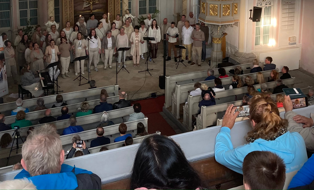 Gospel zu Pfingsten - Zuschauer und Gospelchor in der St. Georg Kirche in Schöneck