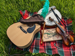 Gruppe MInstrel (Gitrarre, Violine, Flöten, Trommel und ein Hut liegen auf einer Decke in einer Wiese)