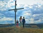 3 Kinder stehen neben dem Kreuz auf dem Steinigtberg