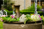 Taufbecken geschm&uuml;ckt mit Blumen und einem Wasserkrug